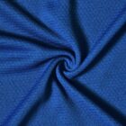 Close-up of blue textured fabric with a folded swirl pattern in the center.