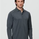 Man in a gray, long-sleeve polo shirt standing against a plain backdrop.