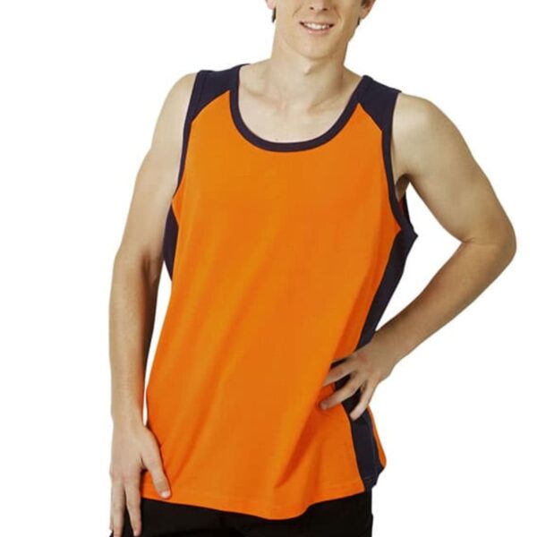Young man in an orange sleeveless shirt and black pants, standing and smiling.