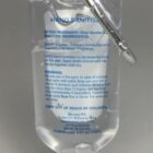 Clear bottle of hand sanitizer with a metal clip and blue text on the label.