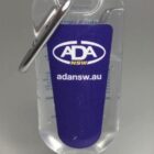 Clear hand sanitizer bottle with a blue ADA NSW label and a metal clip attached.