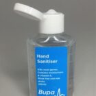 Clear bottle of Bupa hand sanitiser with blue label and open white cap.