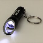 Small keychain flashlight with a bottle opener, emitting white light.