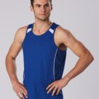 Man in blue athletic tank top with hands on hips against a gray background.
