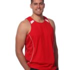 Person in a red sleeveless shirt smiling with hands in pockets.