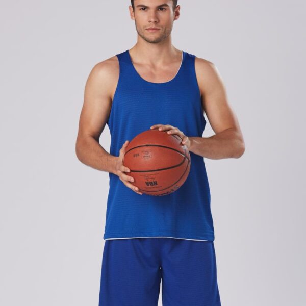 Man in blue sportswear holding a basketball, standing against a plain background.