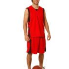 Man in red basketball uniform standing with a basketball on the floor.