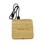 Square bamboo Nespresso wireless charger with a black USB charging cable attached.