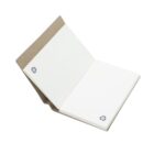 An open notebook with a brown cardboard cover and white pages. Each page displays a recycling symbol in the corner. The notebook is standing on a white background, showing its eco-friendly design.