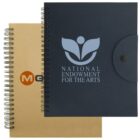 Two spiral-bound notebooks are shown. The front one is black with the National Endowment for the Arts logo. The back notebook is kraft-colored with a partial orange and black logo. Both have a spiral binding on the left.
