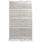 A beige rectangular towel with horizontal stripe patterns and fringe tassels along the shorter edges.