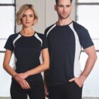 Two people wearing matching black and white sports shirts standing indoors.