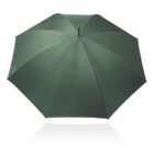 A large, fully open umbrella with a dark green canopy is seen against a plain white background. The umbrellas metal tip is centered, and its ribs extend symmetrically to form a circular shape.