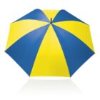 A large umbrella with alternating blue and yellow panels is open against a white background. The vibrant colors create a striking contrast, and the umbrellas reflection is visible below.