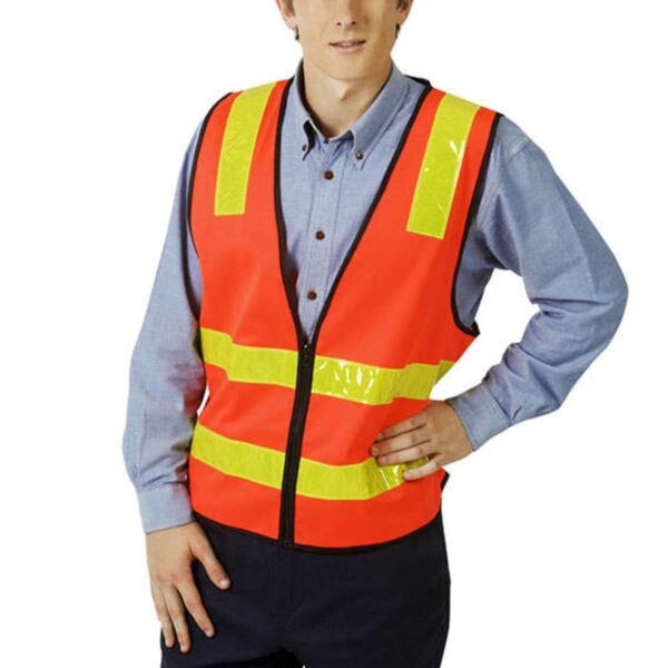 Person in a reflective safety vest and blue shirt standing with one hand on their hip.