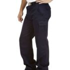 Person in a white shirt, dark cargo pants, and black boots standing with hand on hip.