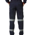 Person in high-visibility workwear, orange top, navy pants with reflective stripes, standing.