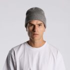 Man in a gray beanie and white t-shirt looking forward with a neutral expression.