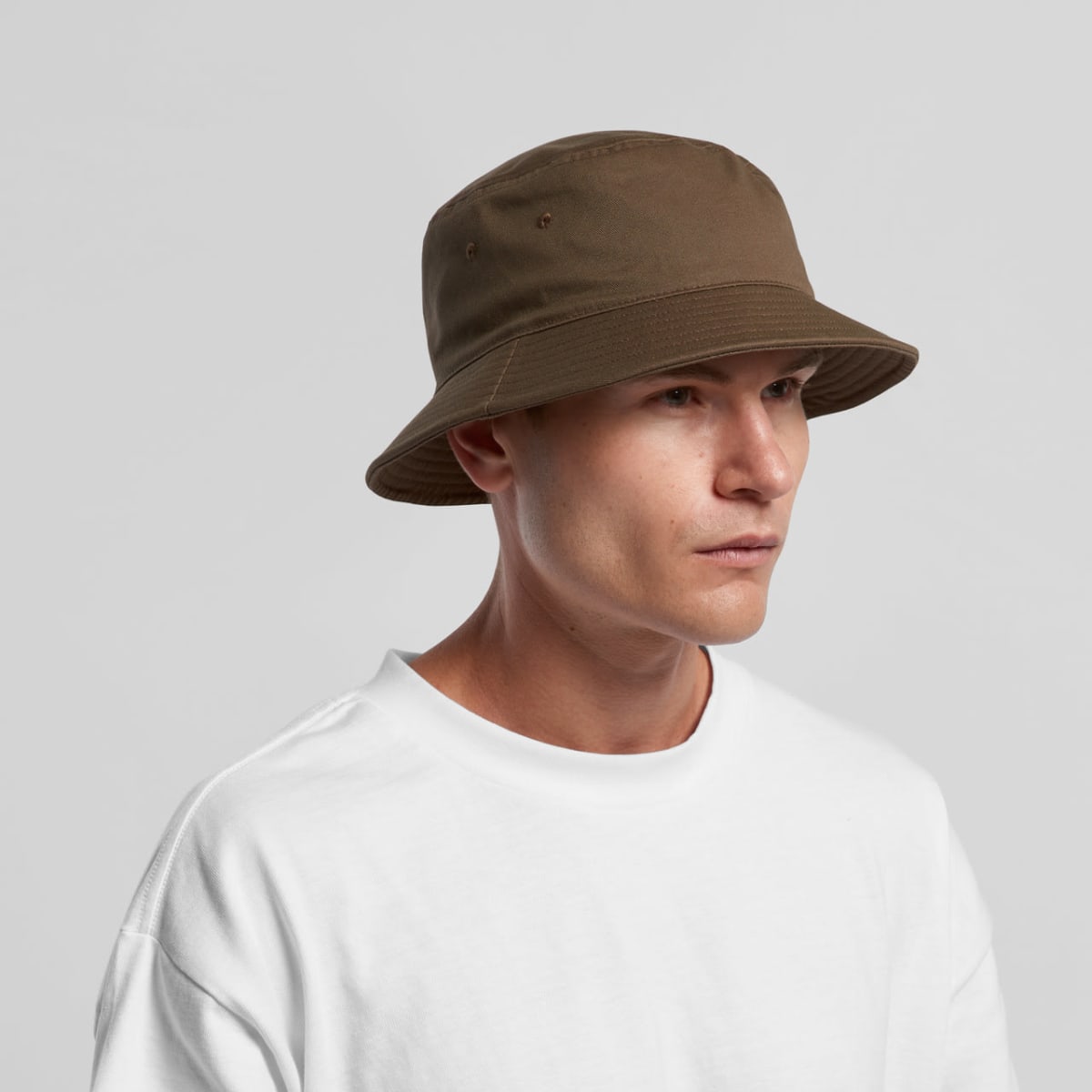 Man in a white shirt wearing a brown bucket hat, looking slightly to the right.