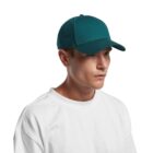 Person wearing a teal baseball cap and white shirt against a plain background.
