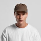 Man in a brown cap and white shirt looking straight at the camera against a gray background.