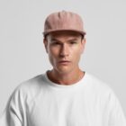 Man in a white shirt and pink cap looking straight at the camera with a neutral expression.