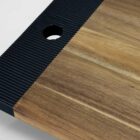 Wooden cutting board with a black textured edge and a hole in the corner.
