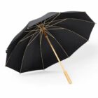 Black umbrella with a wooden handle and metal frame, open on a white background.