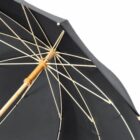 Close-up of a black umbrella with wooden handle and visible ribs.