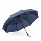 A blue umbrella with a black handle and wrist strap, slightly open.