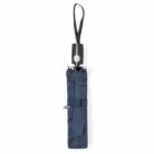 Closed blue umbrella with a black handle and strap, standing upright.