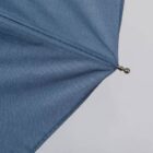 Close-up view of a blue umbrellas fabric and metal tip.