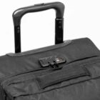 Close-up of a black suitcase handle and lock on a white background.