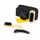 Shoe care kit with brushes, cloth, polish, and black bag.