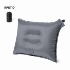 Gray inflatable pillow with a central indentation, next to a black cylindrical carrying pouch.