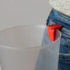 Plastic jug clipped to jeans pocket with a red carabiner.
