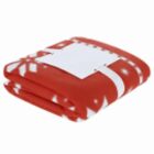 Folded red blanket with white snowflake patterns and a blank white tag on top.