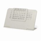A white perpetual desk calendar with adjustable panels displaying days and dates.