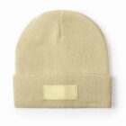 Beige knit beanie with a folded cuff and a blank rectangular patch on the front.