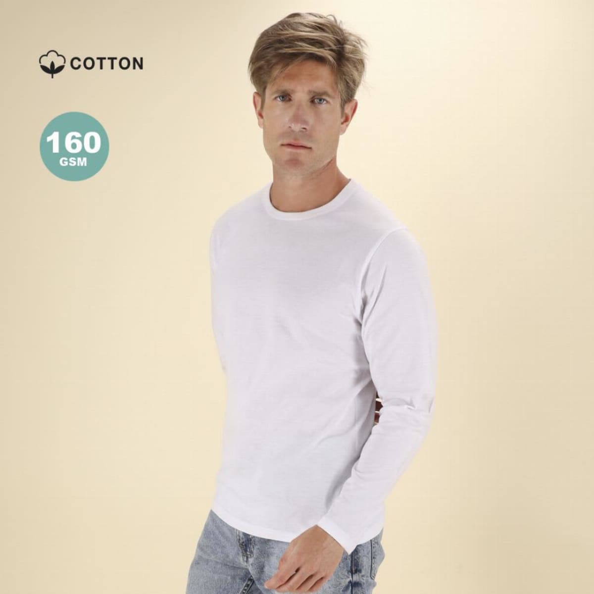 Man in a white long-sleeve shirt and jeans stands against a light beige background.