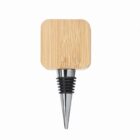 A wine bottle stopper with a square wooden top and a metal, cone-shaped base.