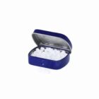 A blue tin box filled with small white mints, lid open.