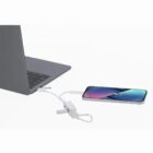 A laptop charging a smartphone via a USB cable and adapter.