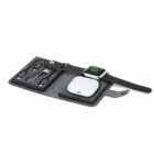 A gray tech organizer with gadgets, charging cables, and a smartwatch on top.