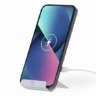 Smartphone on a wireless charging stand with a charging symbol on the screen.