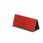 Red triangular wireless charging stand with a cable plugged in, set against a white background.