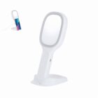 White tabletop mirror with stand and a built-in phone holder on the back.