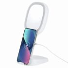 White wireless charging stand holding a smartphone upright, with a charging cable attached.