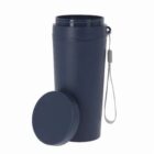 A navy blue travel mug with a lid and a gray carrying strap, lid placed beside the mug.