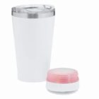 White tumbler with a clear lid next to a small round pink and white portable speaker.